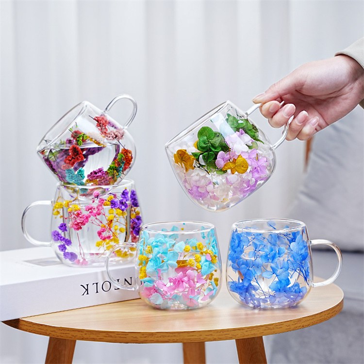 Set of dried flower double wall glass mugs in mixed colors on table Set of dried flower double wall glass mugs in mixed colors on table