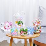 Colorful pressed flower glass mugs arranged on wooden stand