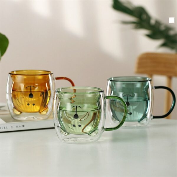 Three animal face double wall mugs in amber green and blue