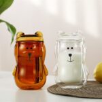 Two amber and clear bear face mugs with milk