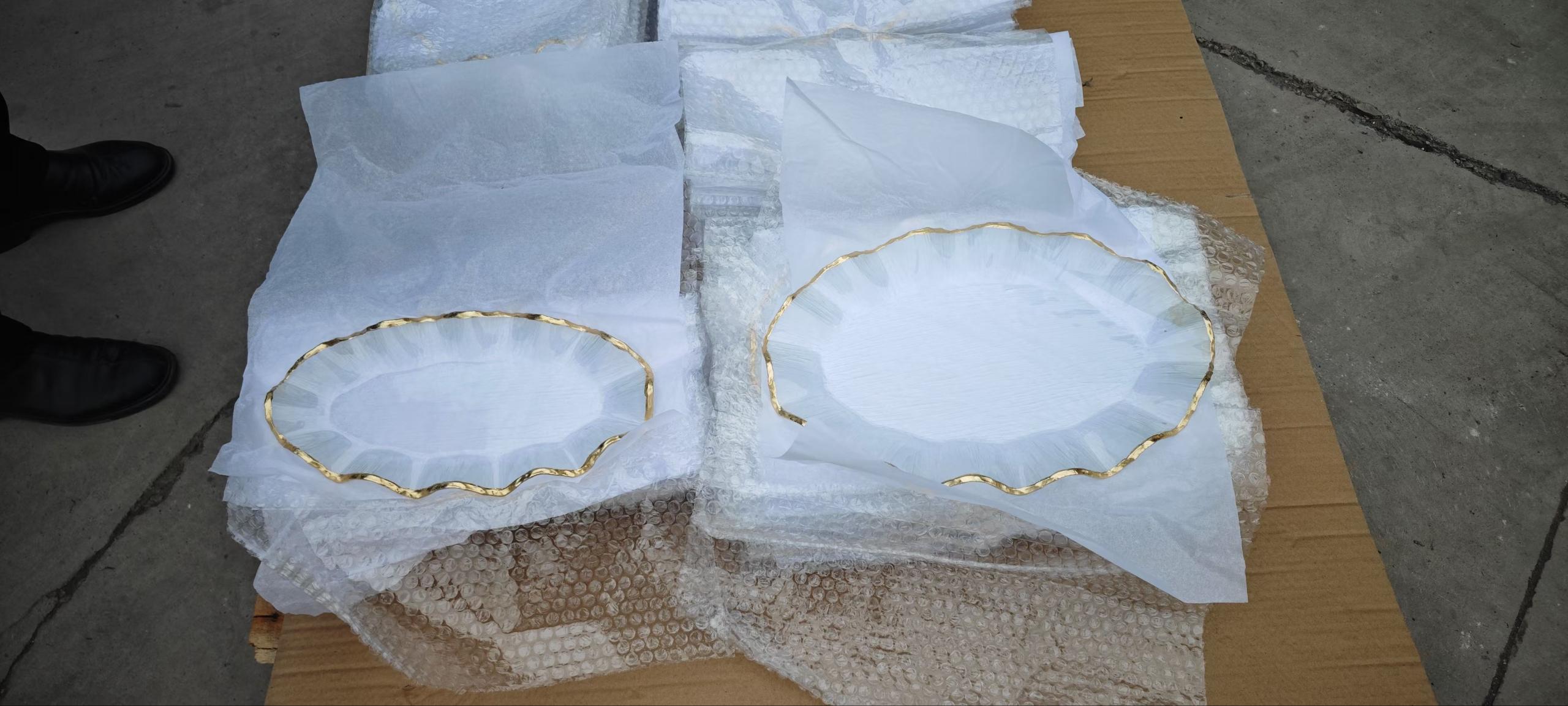 Glass charger plates wrapped in tissue and foam for export packing