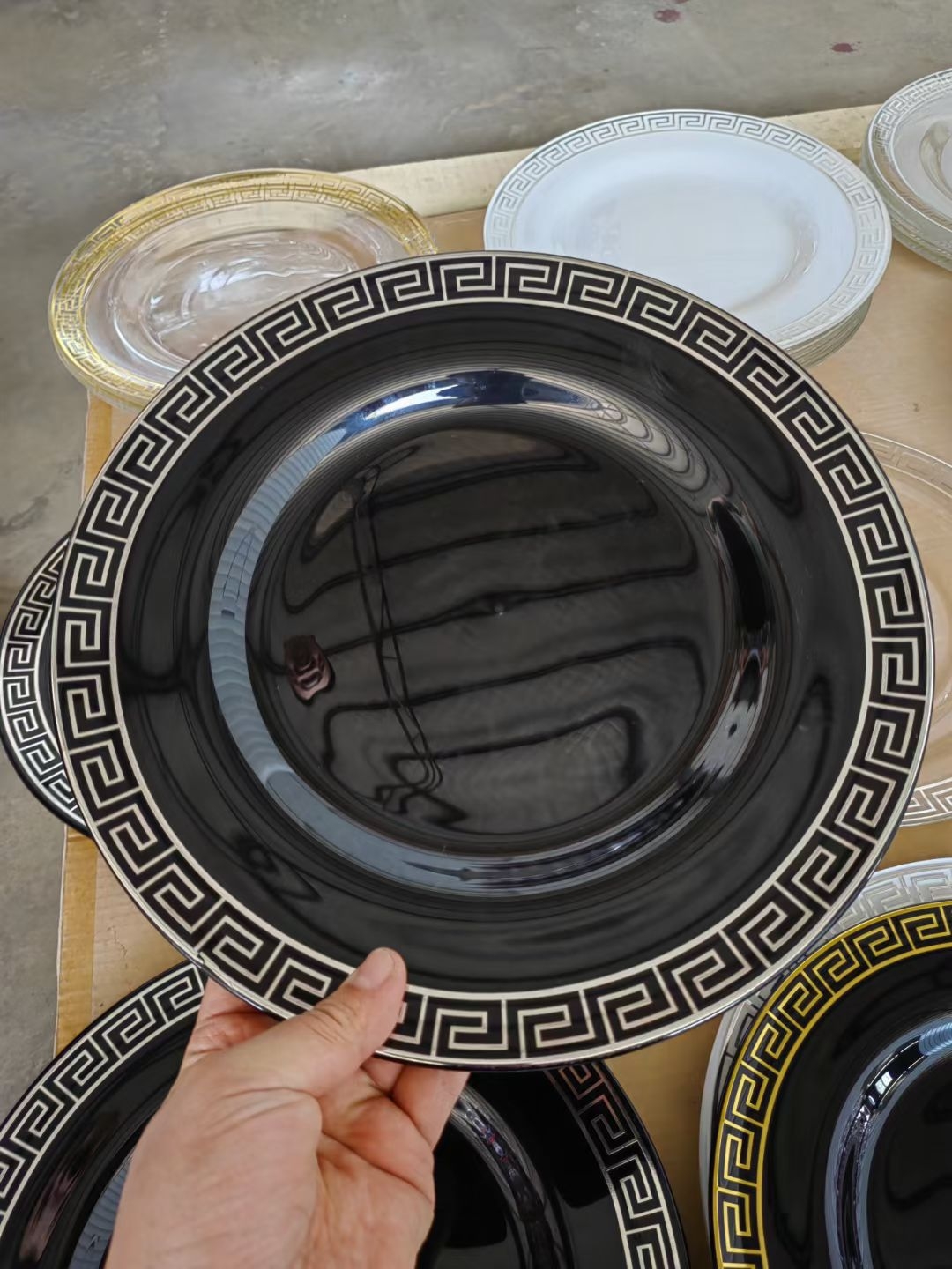 Clear glass charger plate with gold Greek key rim and stacked cups