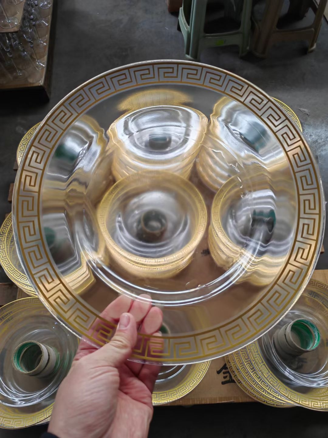 Black glass charger plate with platinum Greek key rim held in workshop