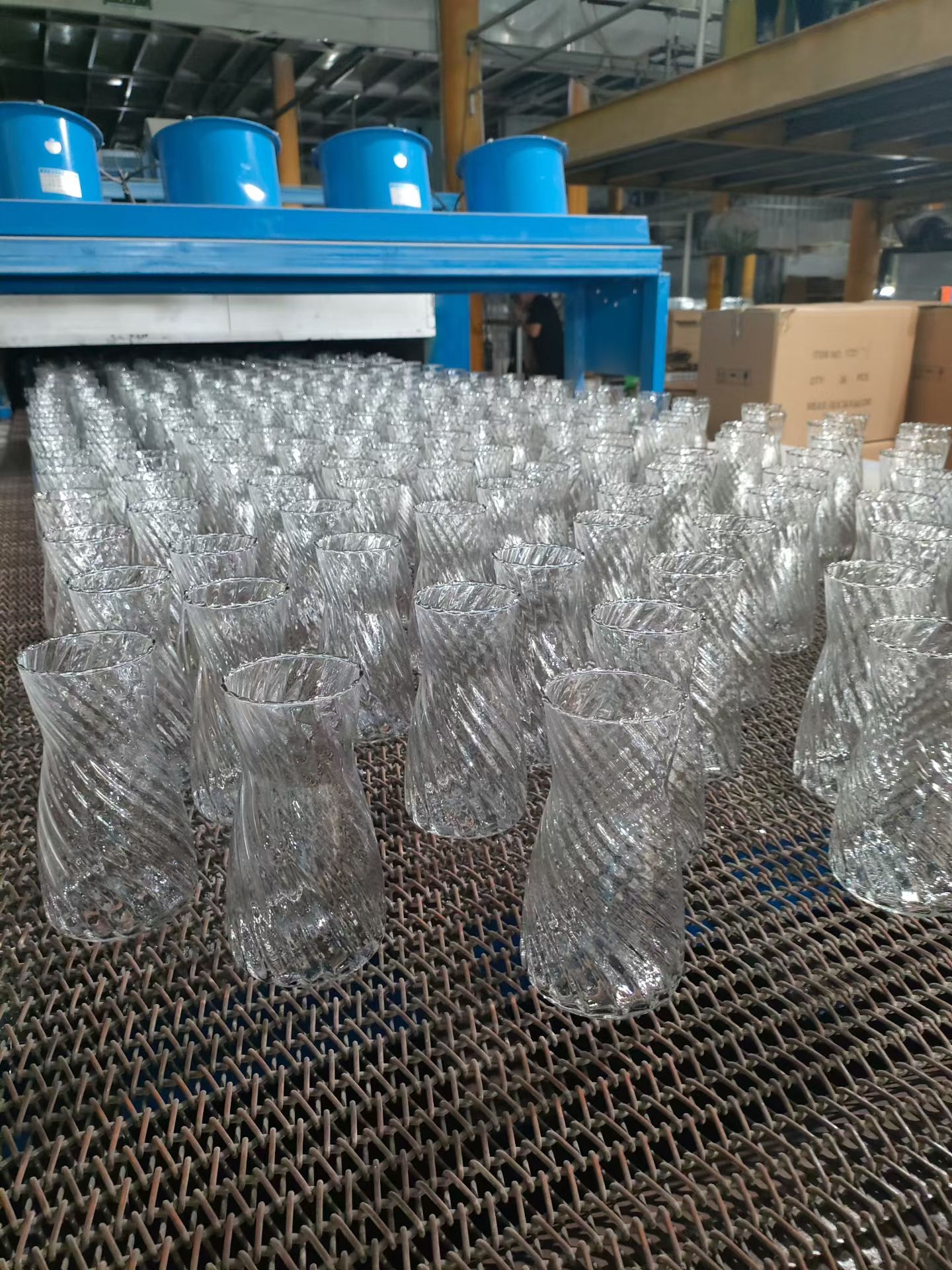 Rows of handmade spiral texture glass vases drying after production