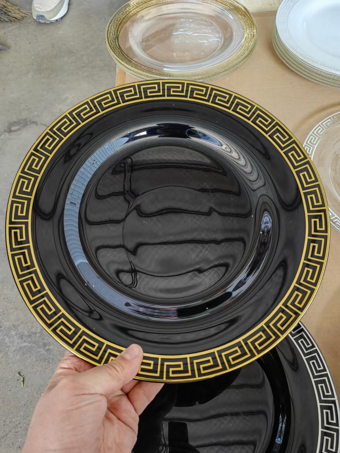Black glass charger plate with gold Greek key decal rim