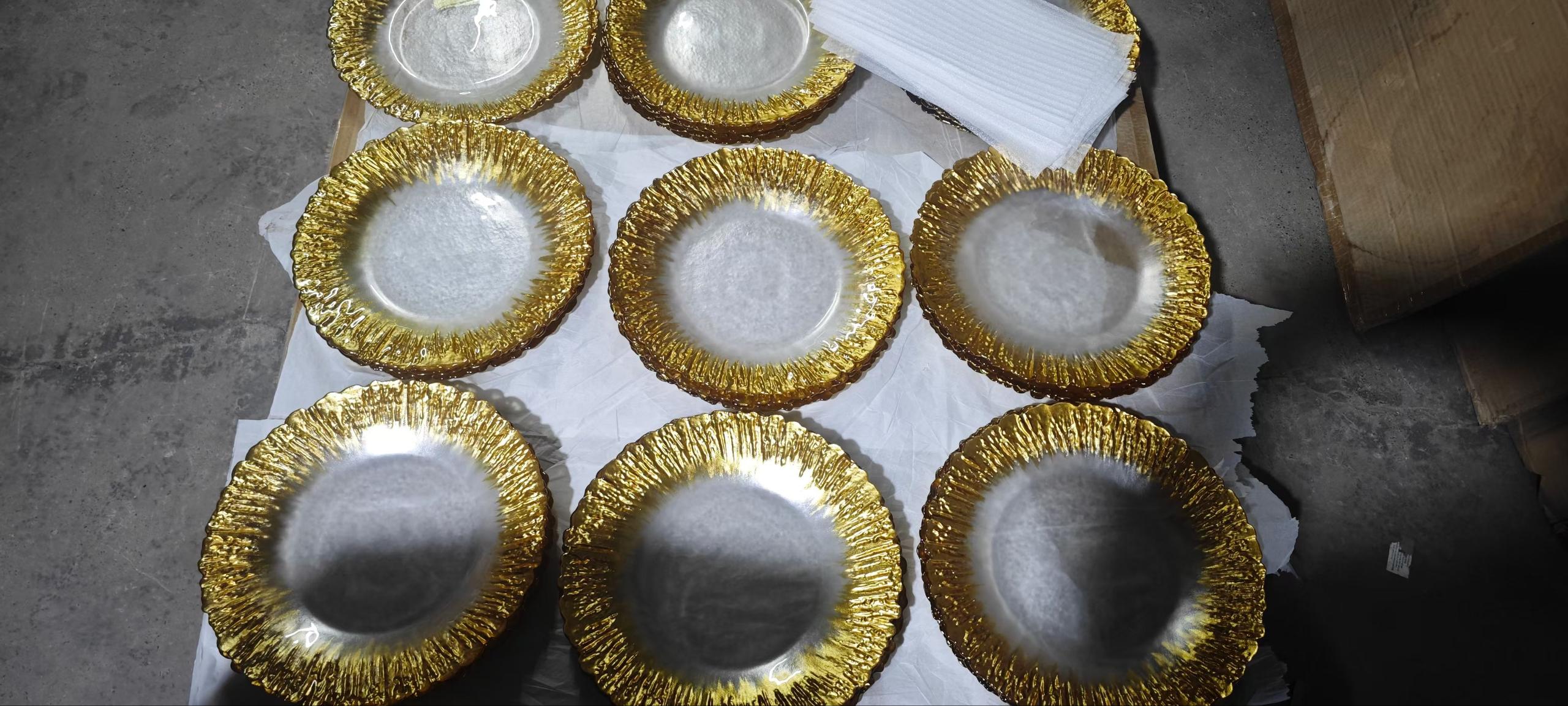 Tray of handmade gold rim clear glass charger plates before packing