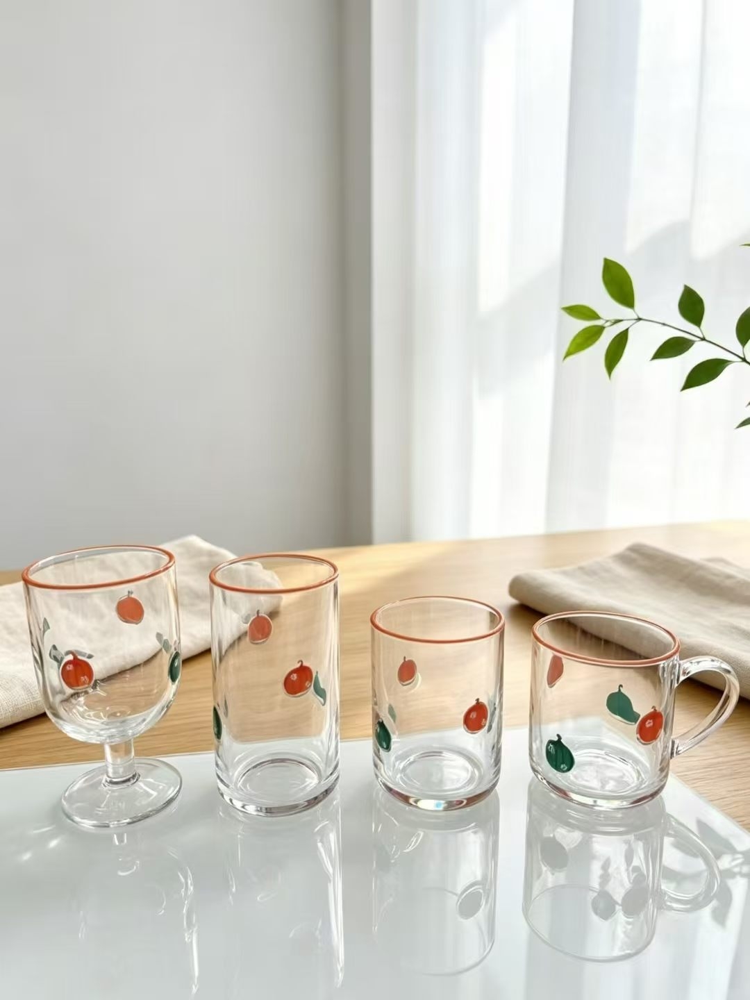 Small crystal glass cups with strawberry decals and gold rims