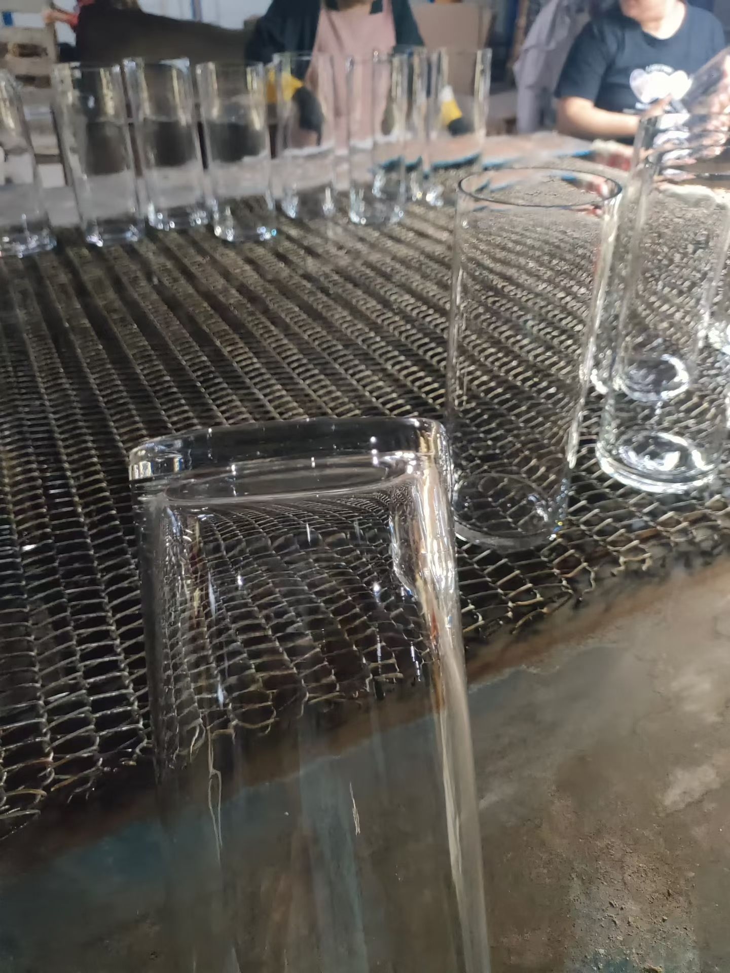 Square-neck tall glass vases lined up for quality check